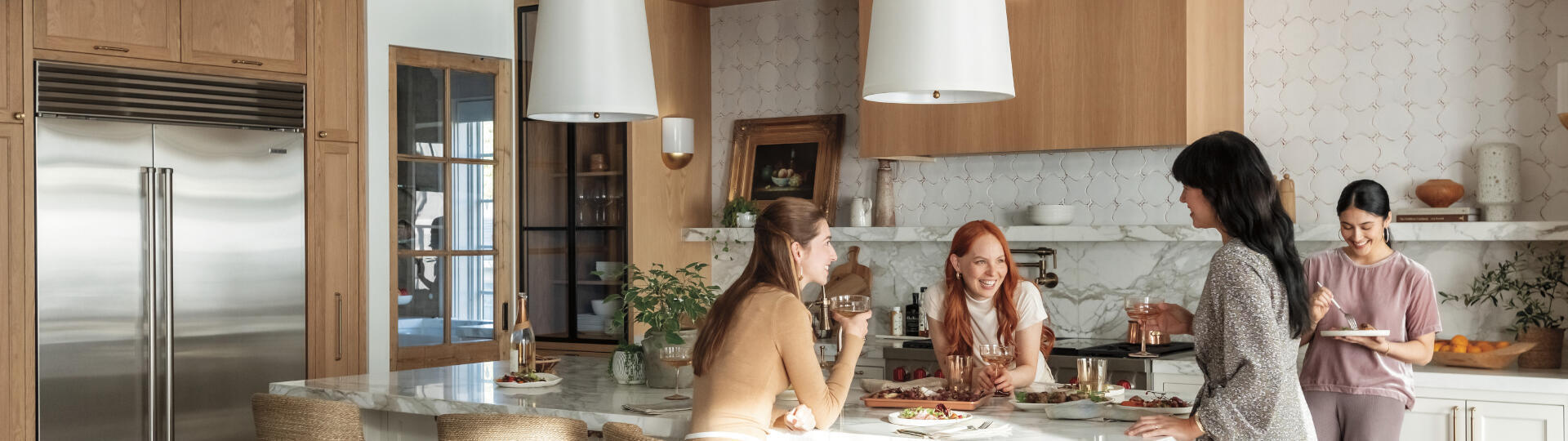 Girls enjoying food and wine that are well-preserved with Sub-Zero's classic refrigerator